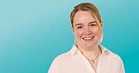 Porträt einer lächelnden Frau vor einfarbigem blauem Hintergrund