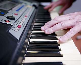 Jemand spielt auf einem elektronischen Keyboard mit sichtbaren Tasten und Bedienelementen