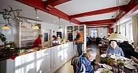 Menschen essen in einem hellen Restaurant mit rotem Holzdekor und Theke