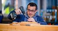 Ein Mann arbeitet mit einem Akku-Bohrschrauber an Holz.
