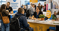 Beratungssituation an einem Messestand zur Inklusion mit Besucher im Rollstuhl